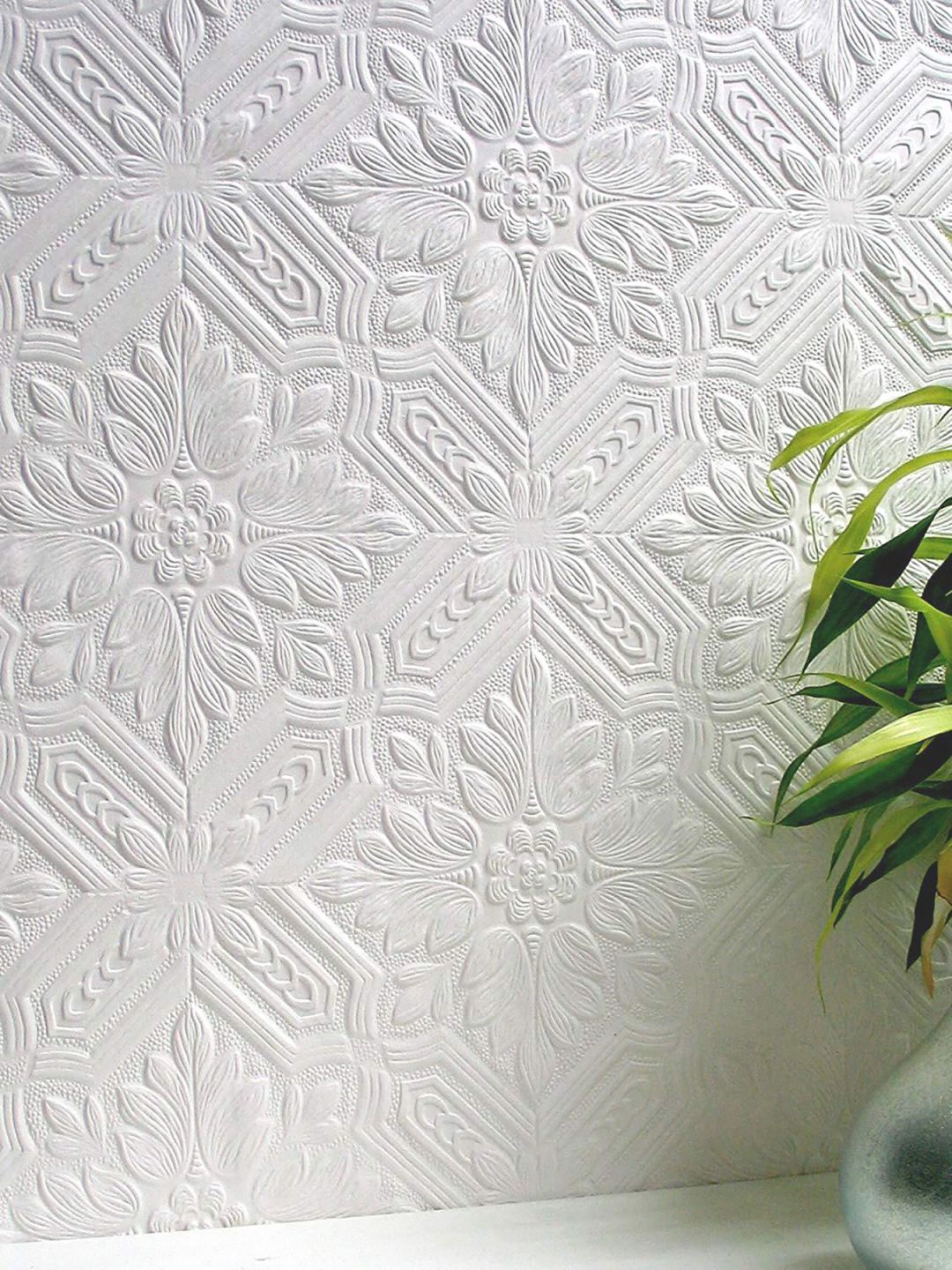 Eine weiße Tapete mit klassischem Muster und Reliefoberfläche, zum Überstreichen geeignet